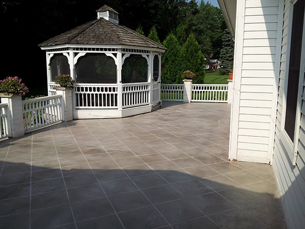 patio behind white home after concrete services