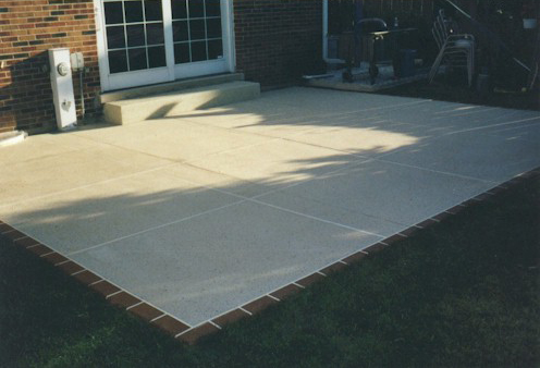 patio after concrete restoration behind brick home