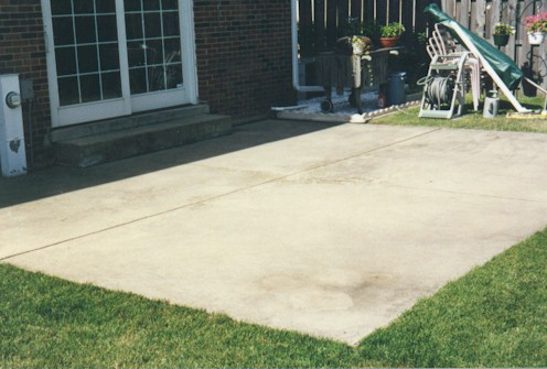 patio before concrete restoration behind brick home